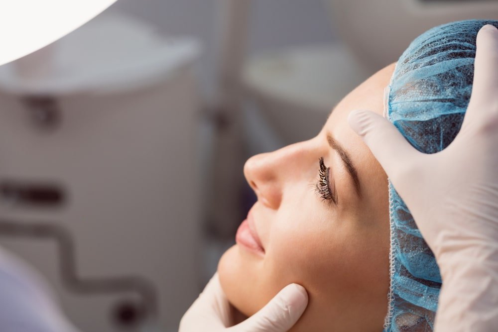 doctor_examining_womans_side_nose_profile_for_revision_rhinoplasty_surgery_in_turkey